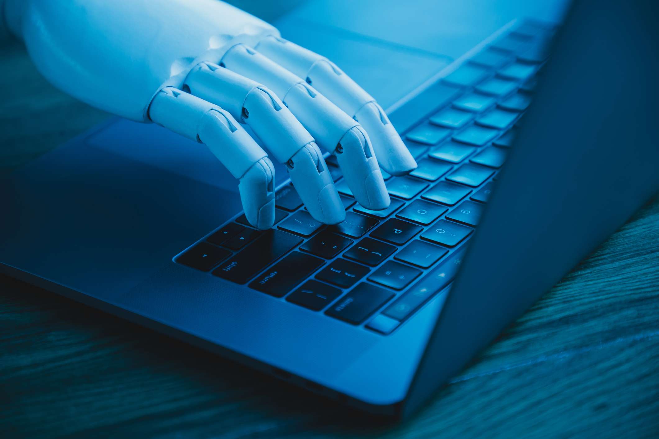 En robothand på ett bärbart tangentbord.