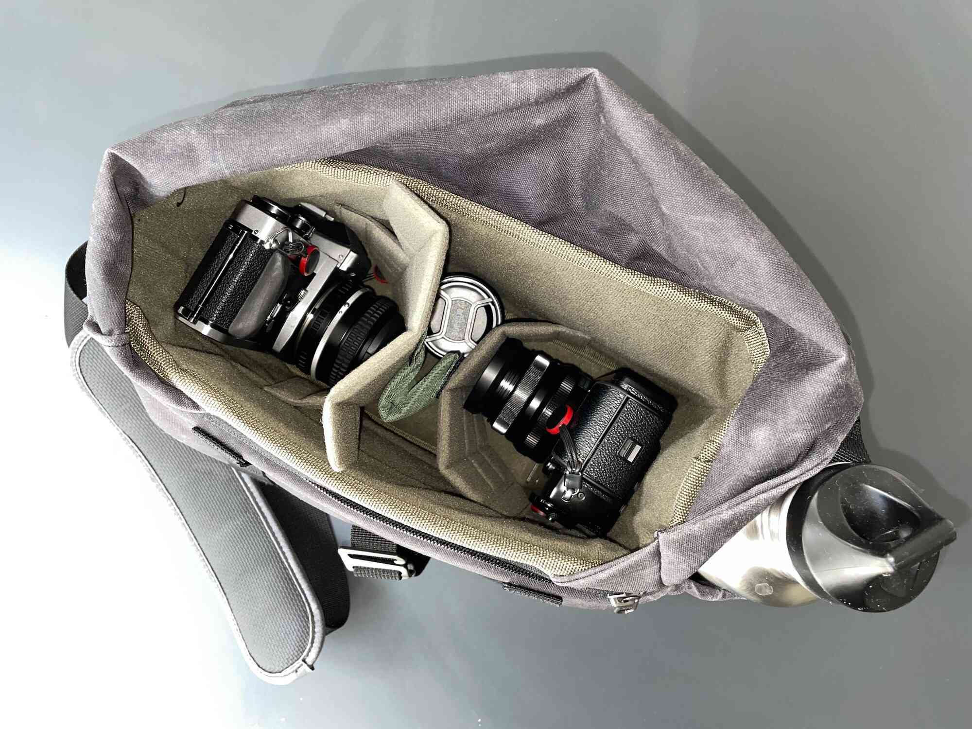 Wotancraft-kameraväskan, öppen med två kameror och en lins i det inre förvaringsområdet. 