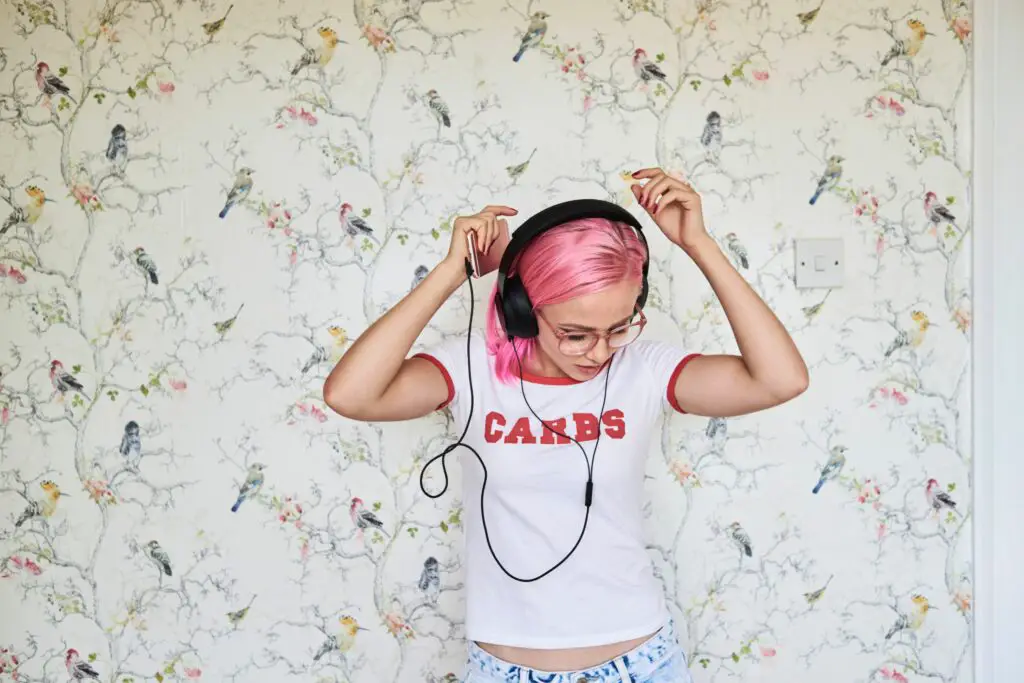 enthusiastic young woman with pink hair listening to music at home 769729481 5b91dd194cedfd0025d904d9 5c8014a746e0fb00011bf415