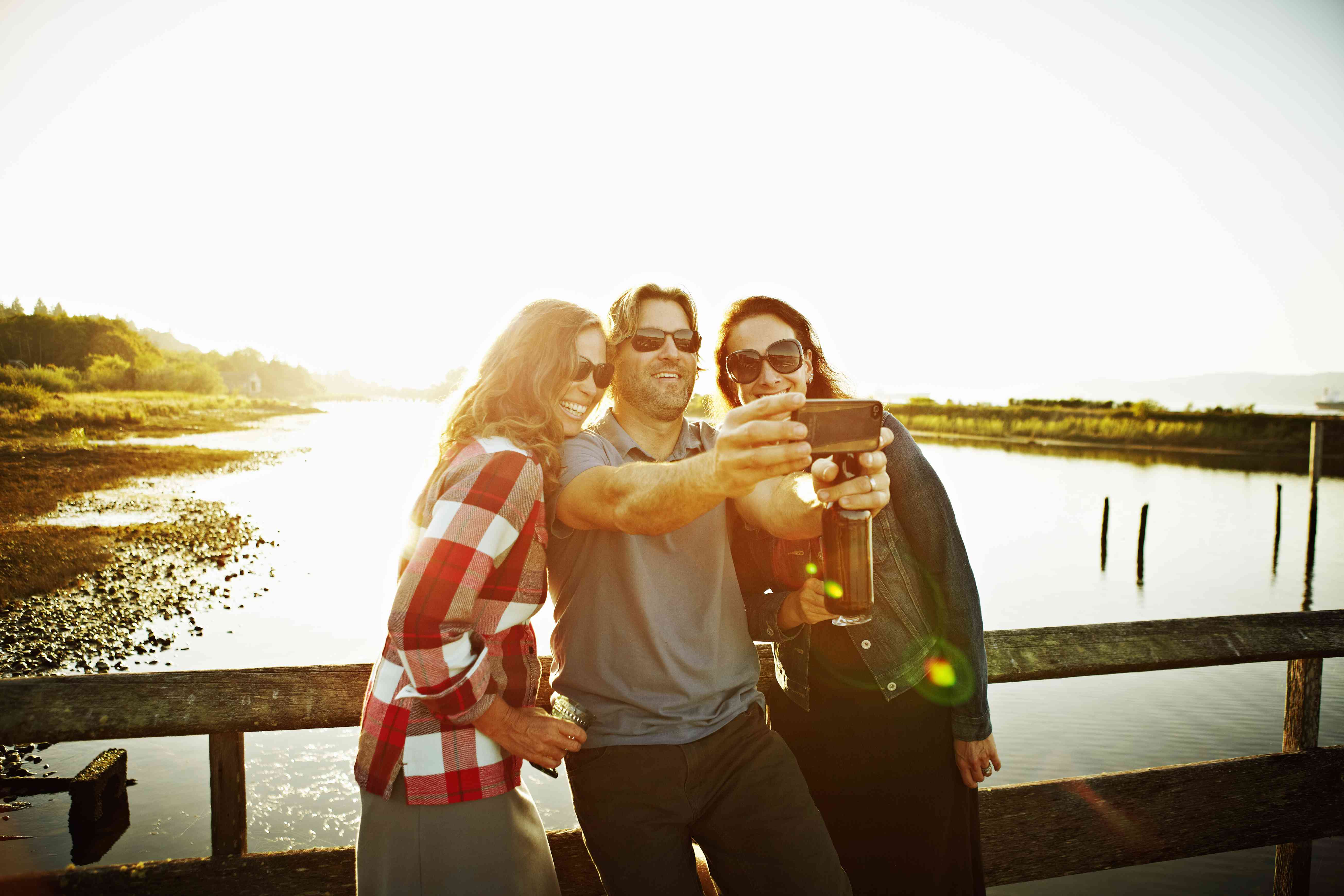 Tre vänner som tar självporträtt med smartphonen