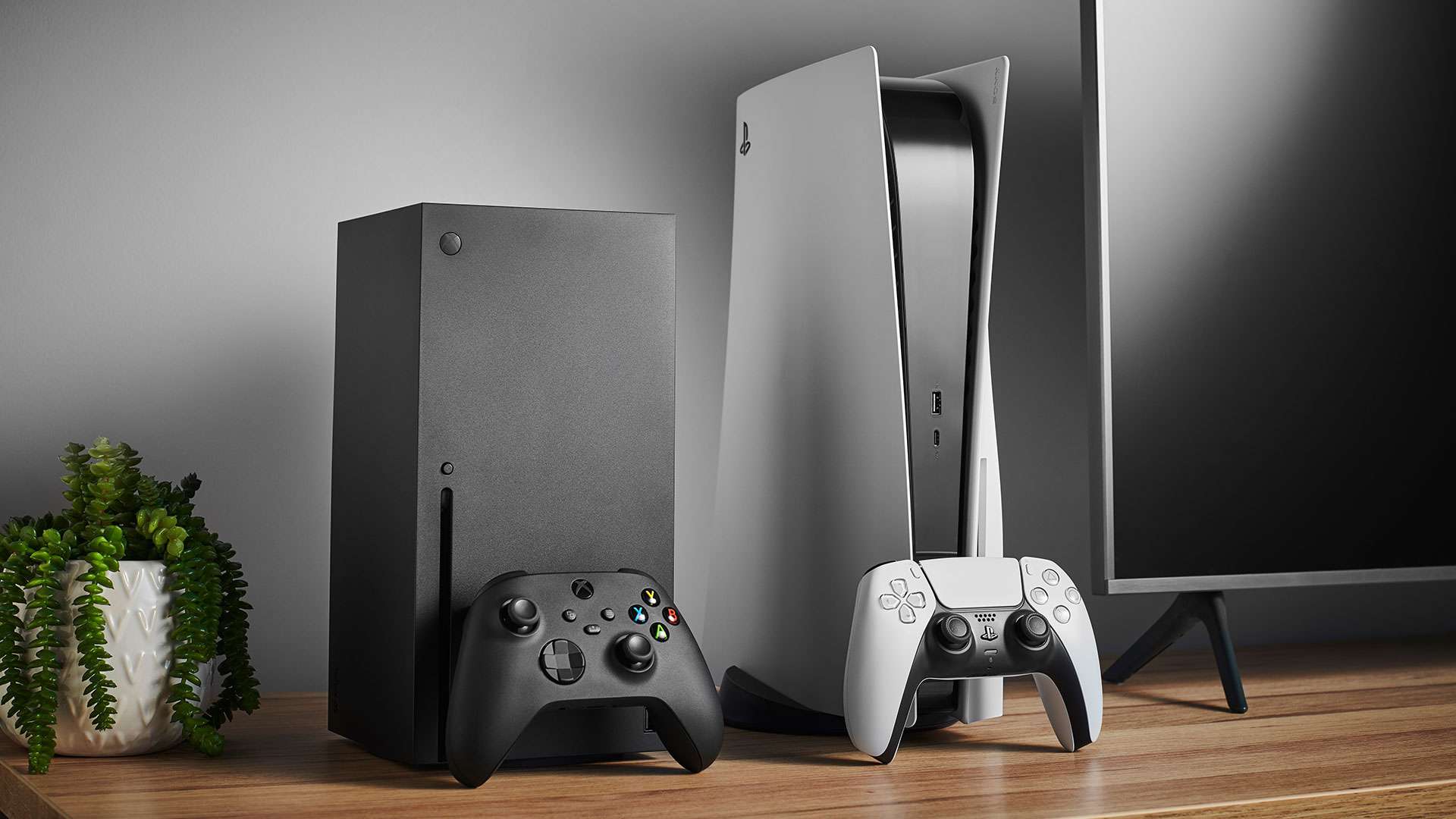 En Xbox Series X och en PS 5 upprättade bredvid varandra på ett nöjescenter med en TV.