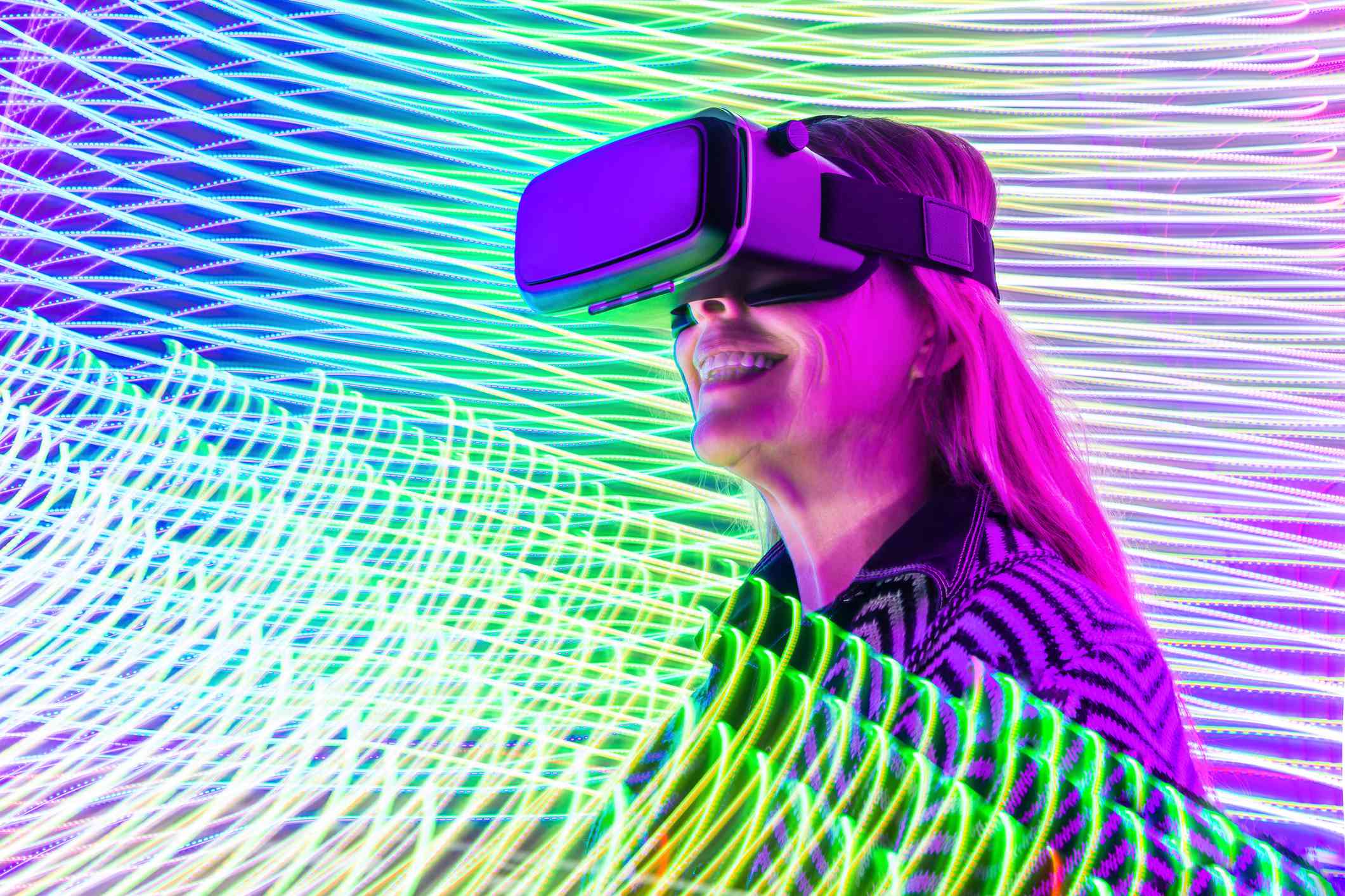 Kvinna som tycker om VR, medan omges av färgglada spiraler