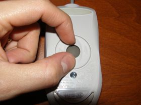 Bild av någon som tar bort styrkulan från en datormus