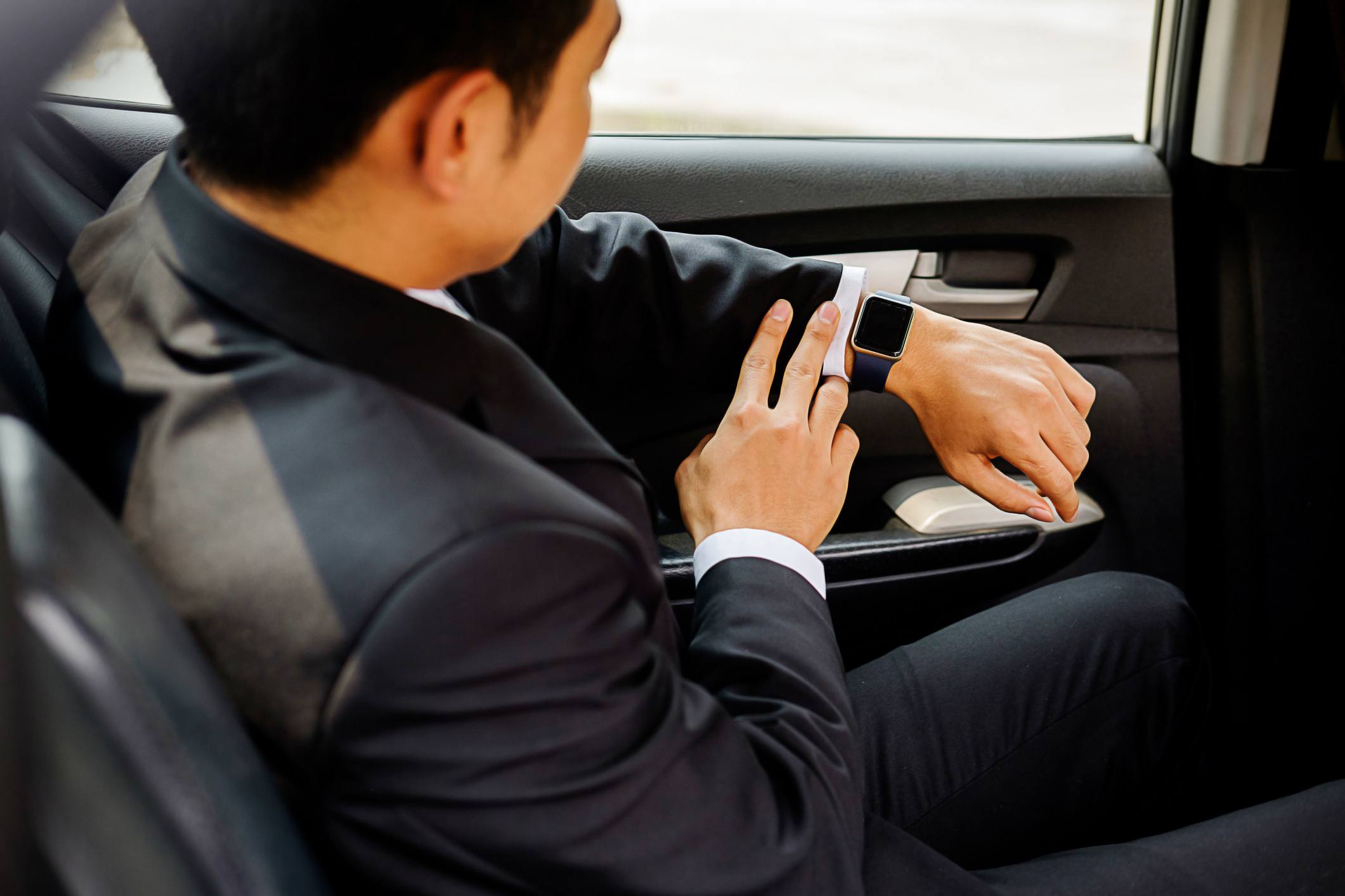 En person som tittar på en Apple Watch medan han sitter i en bil