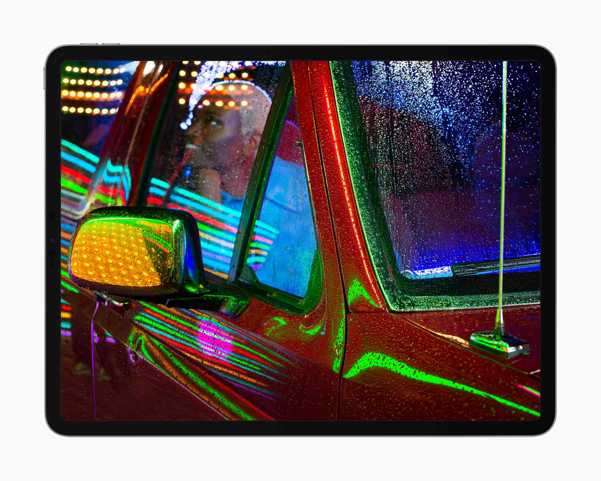 Apple iPad Pro liquidXDR-skärm som visar ett foto av någon i en pickup med neonljus som reflekterar från metallen och glaset.