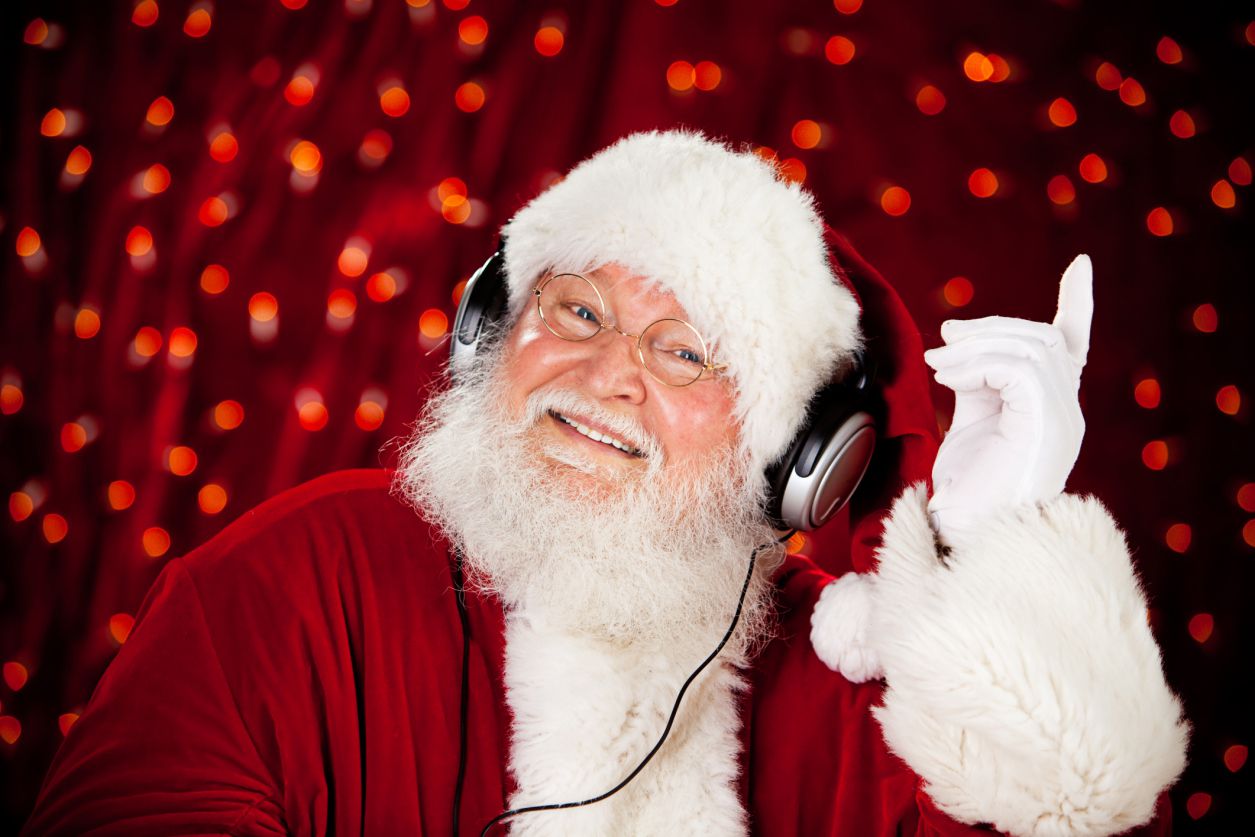 Jultomten som lyssnar på julmusik på hörlurar.