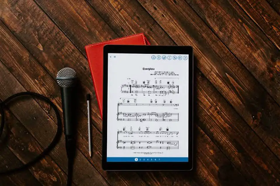 Musicnotes-appen på en iPad som ligger på ett bord bredvid en mikrofon