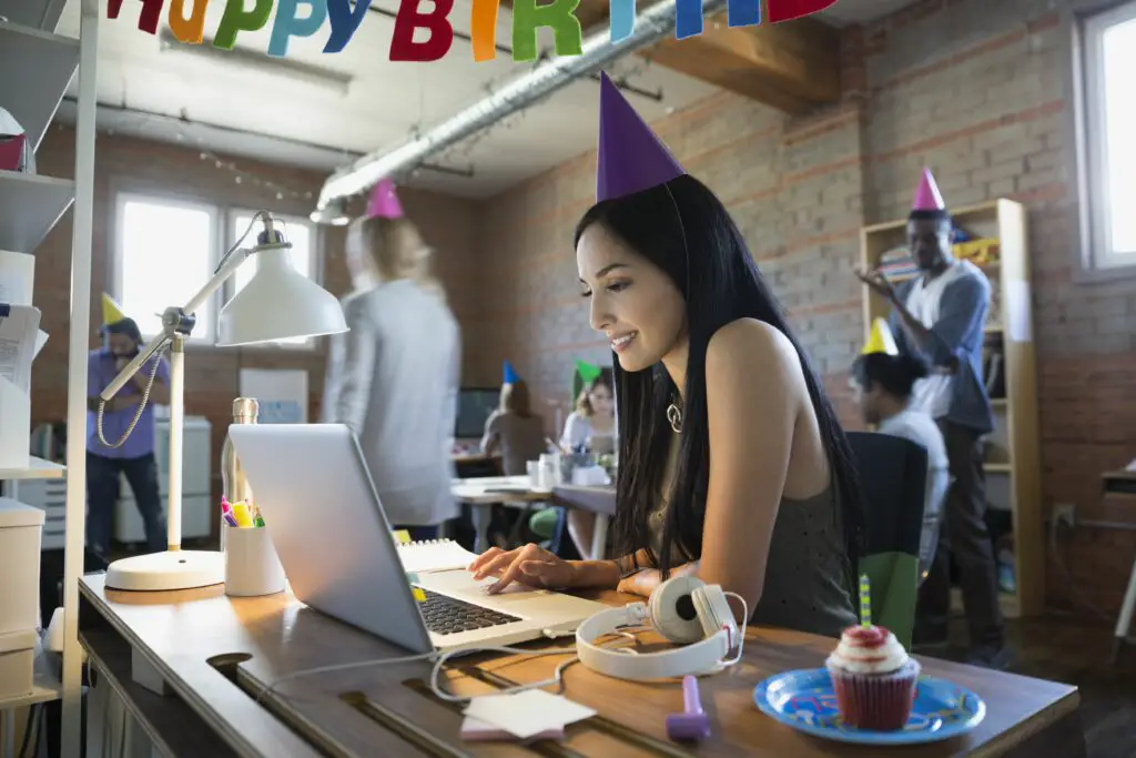 businesswoman wearing birthday party hat at laptop 645426519 5a09fa4c22fa3a003677819c