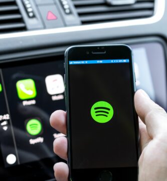 male hands holding a smartphone that is connecting to the car s computer running the popular music streaming service 998425776 5ba049bb46e0fb00509a1fb3