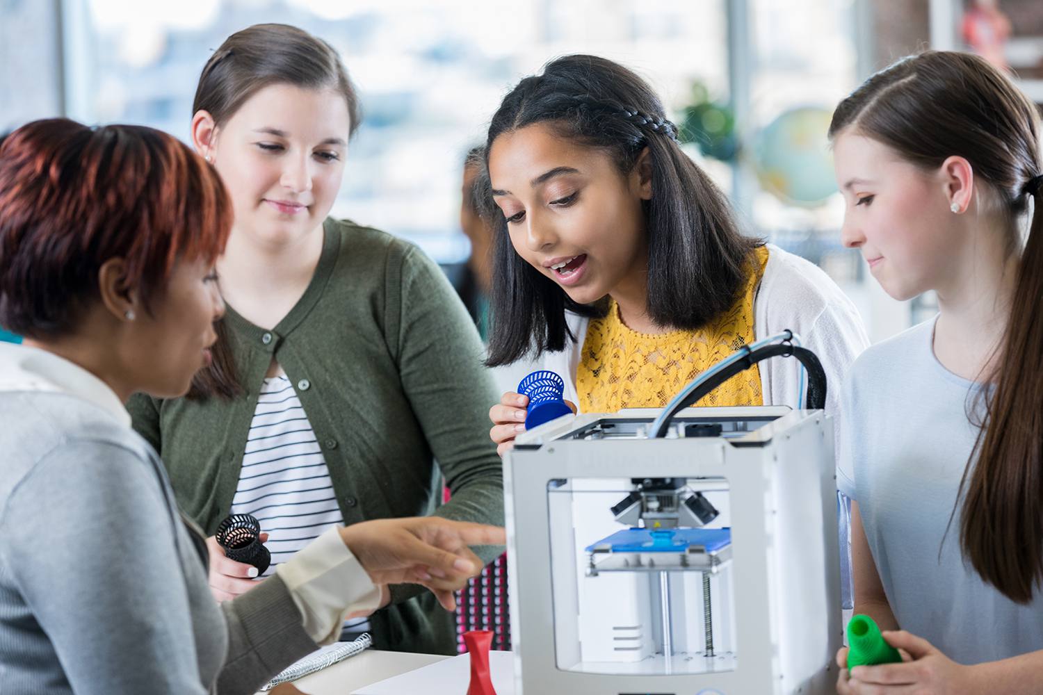 Glada gymnasieelever använder 3D-skrivare
