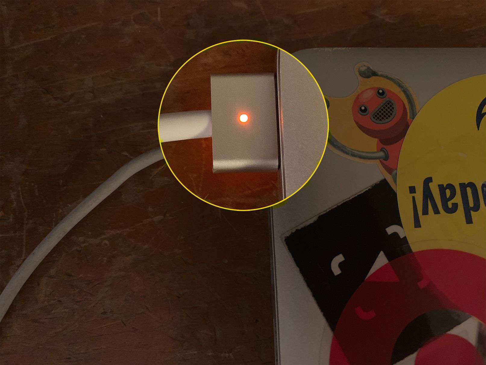 MacBook-laddare med orange ljus som indikerar laddningstillstånd