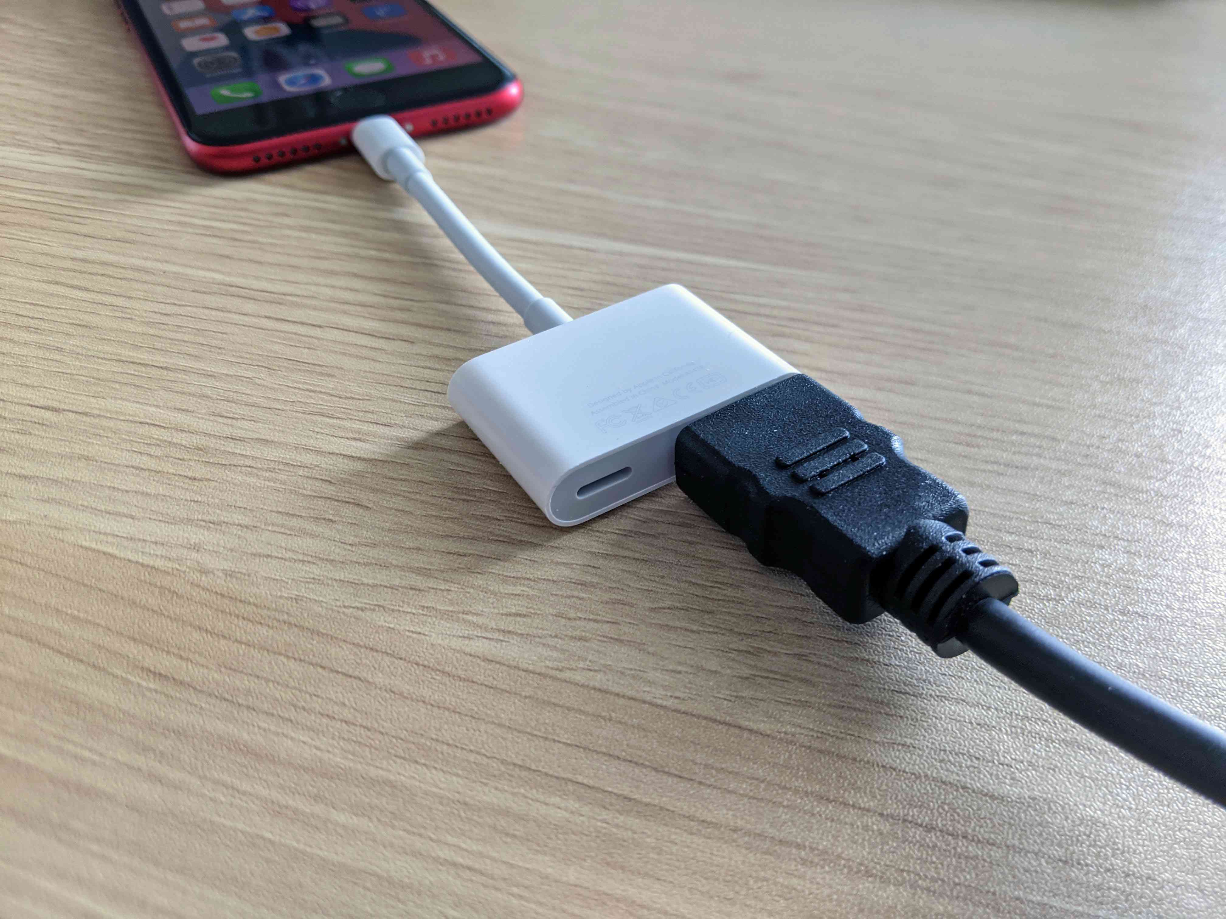 En HDMI-kabel ansluten till en iPhone med en adapter.