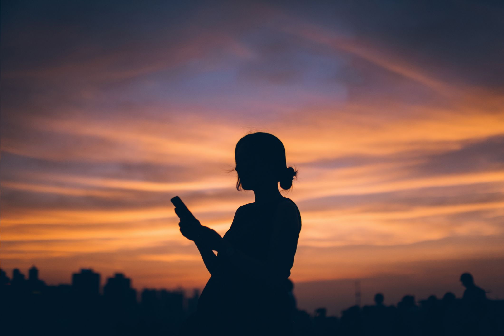 Kvinna på telefonen silhuett vid solnedgången