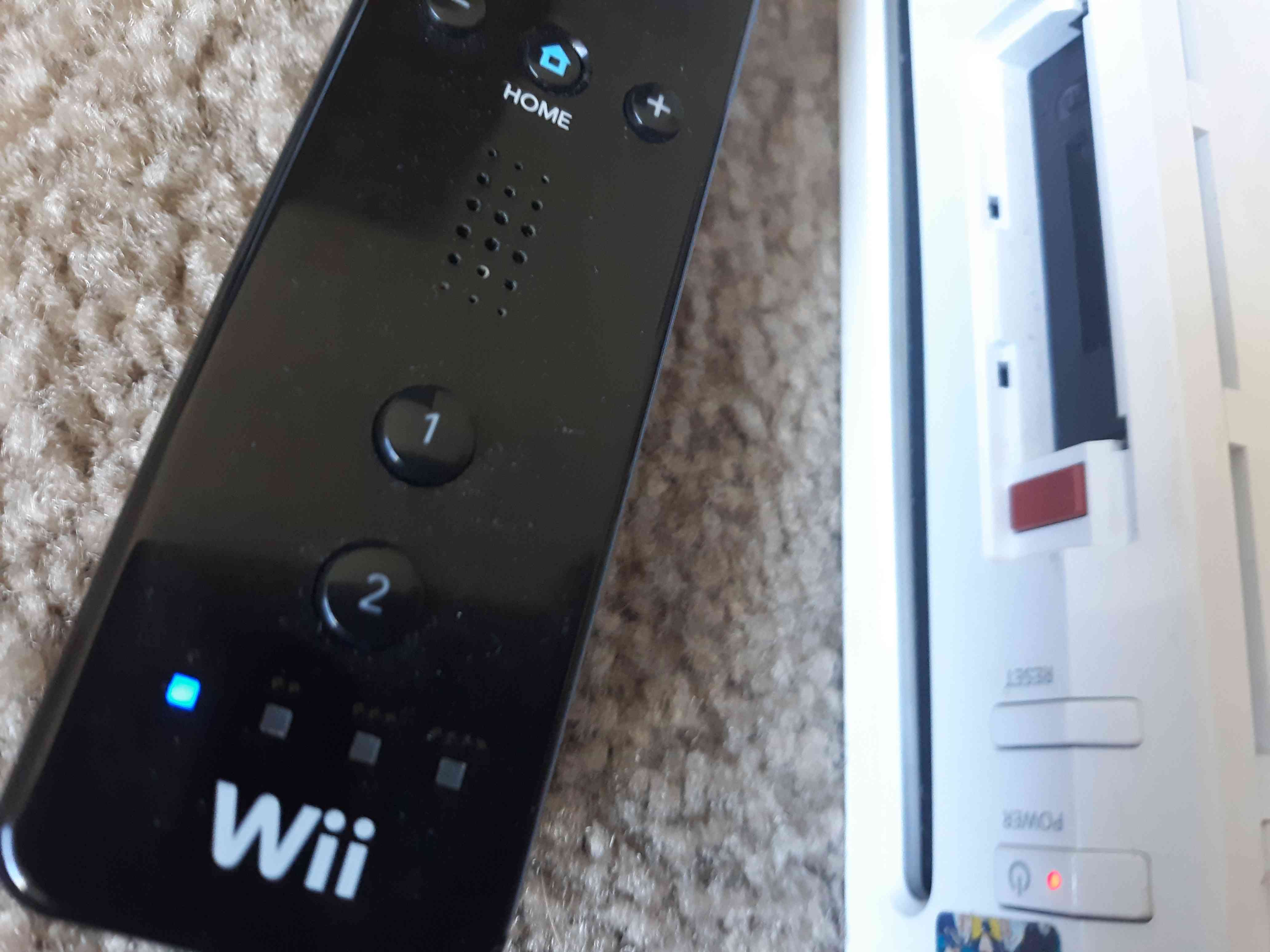LED-lampan på Wii-fjärrkontrollen blinkar bredvid den röda synkroniseringsknappen på Wii.