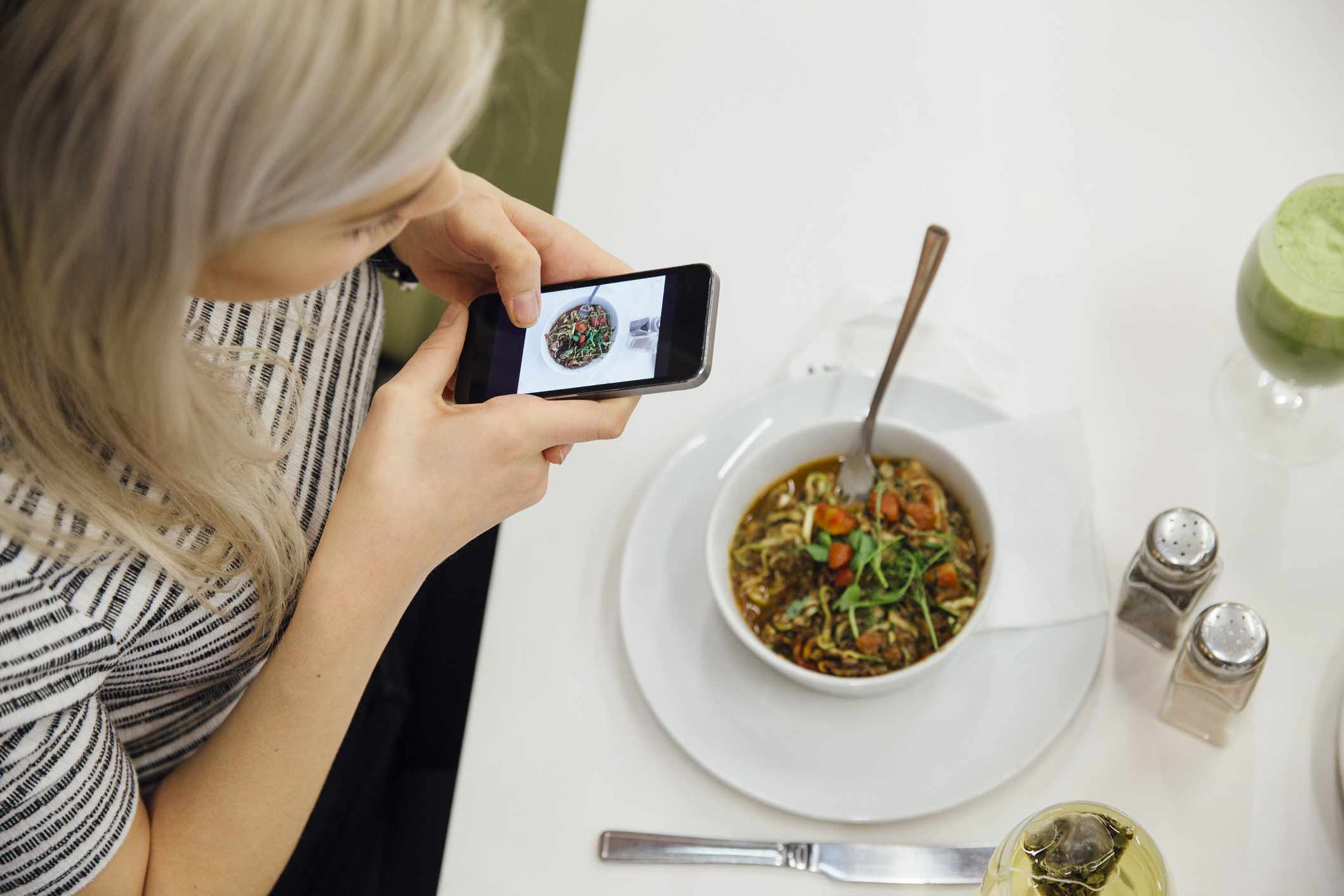 Person som tar en bild av deras måltid på en smartphone.
