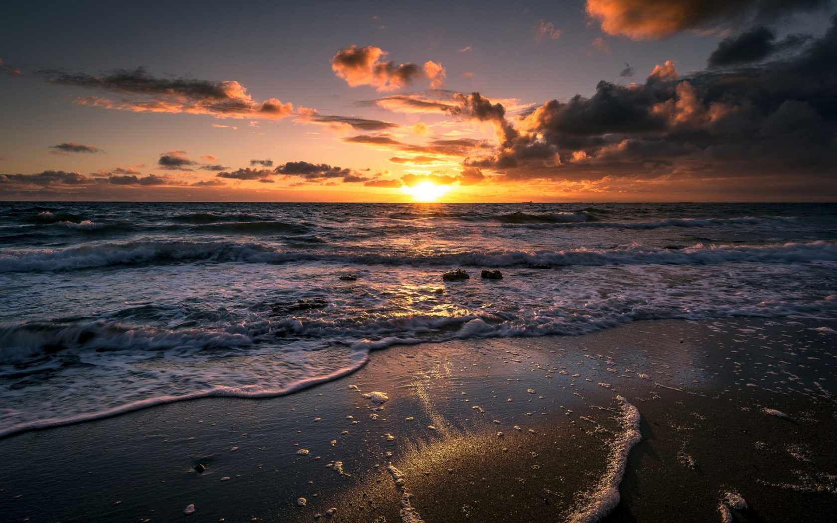 Gratis havsbakgrund med utsikt över stranden av en soluppgång över skummande hav