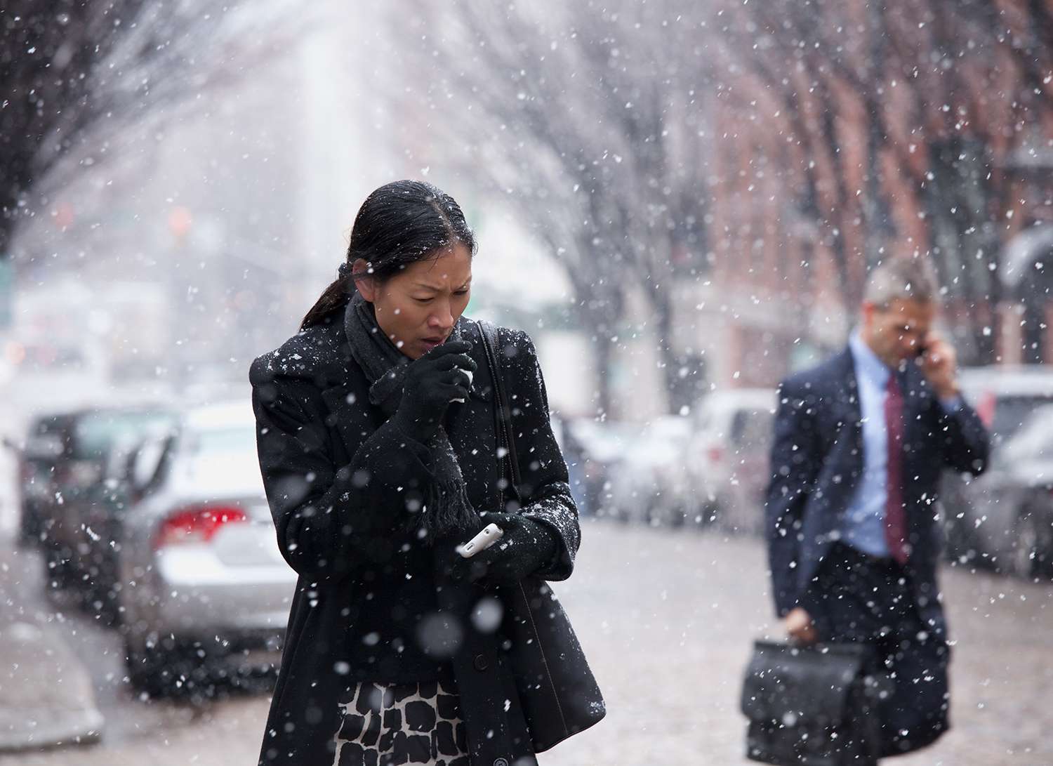 Asiatisk kvinna som går i snö och hostar