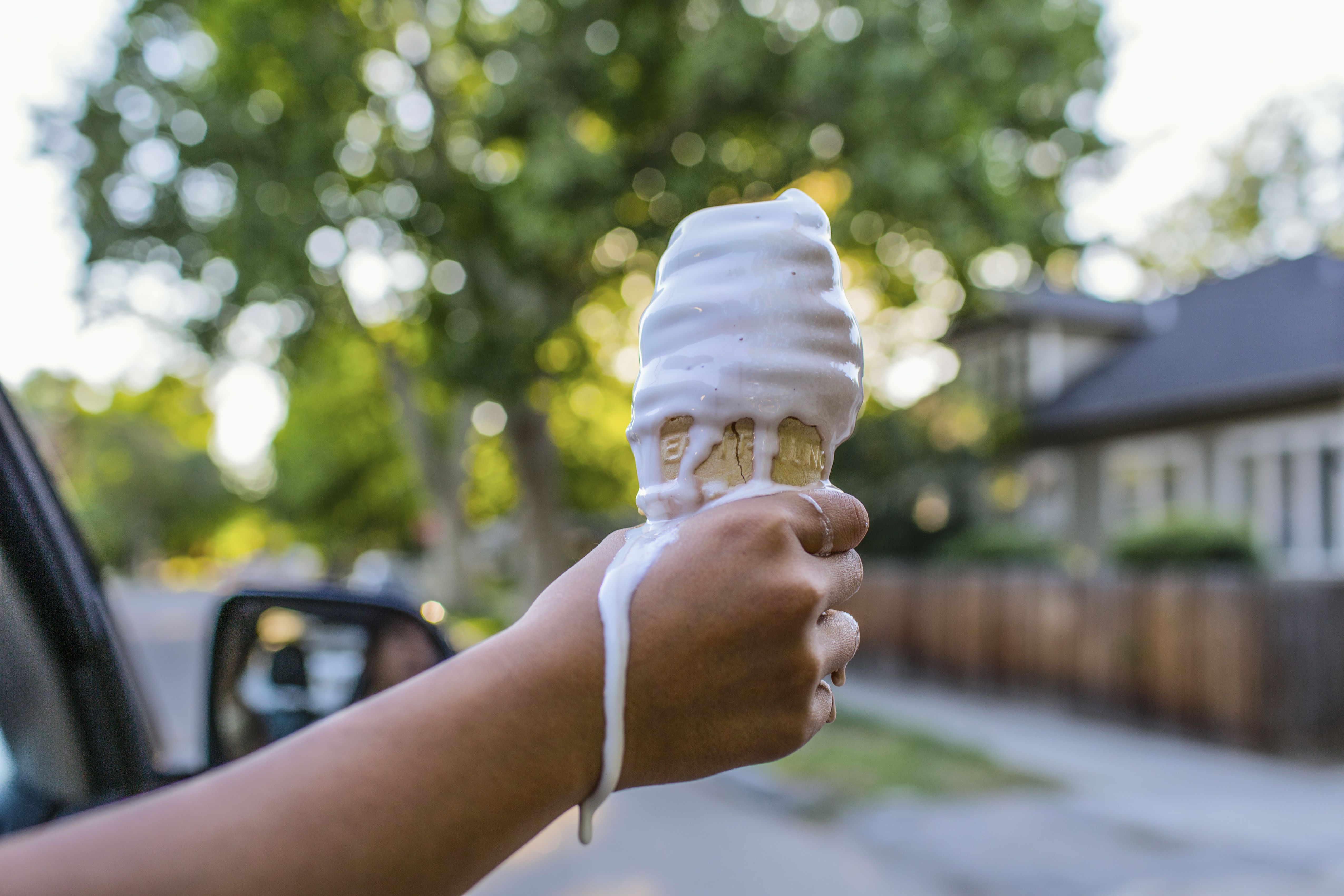 Närbild av flickans hand som håller smältande glass
