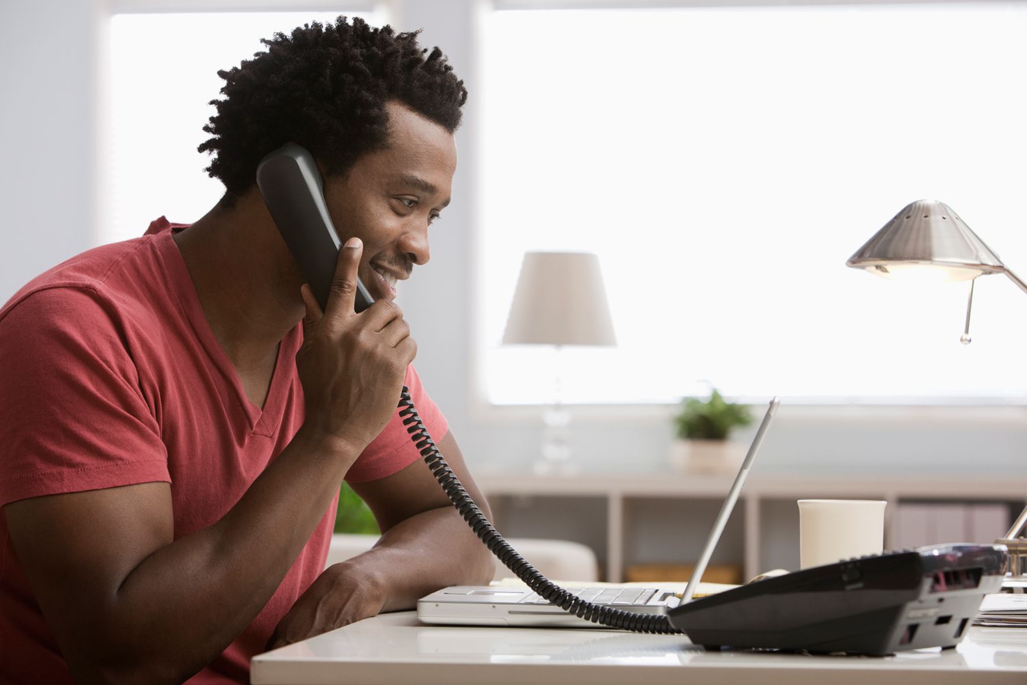 Le svart man som talar på telefonen på hemmakontoret