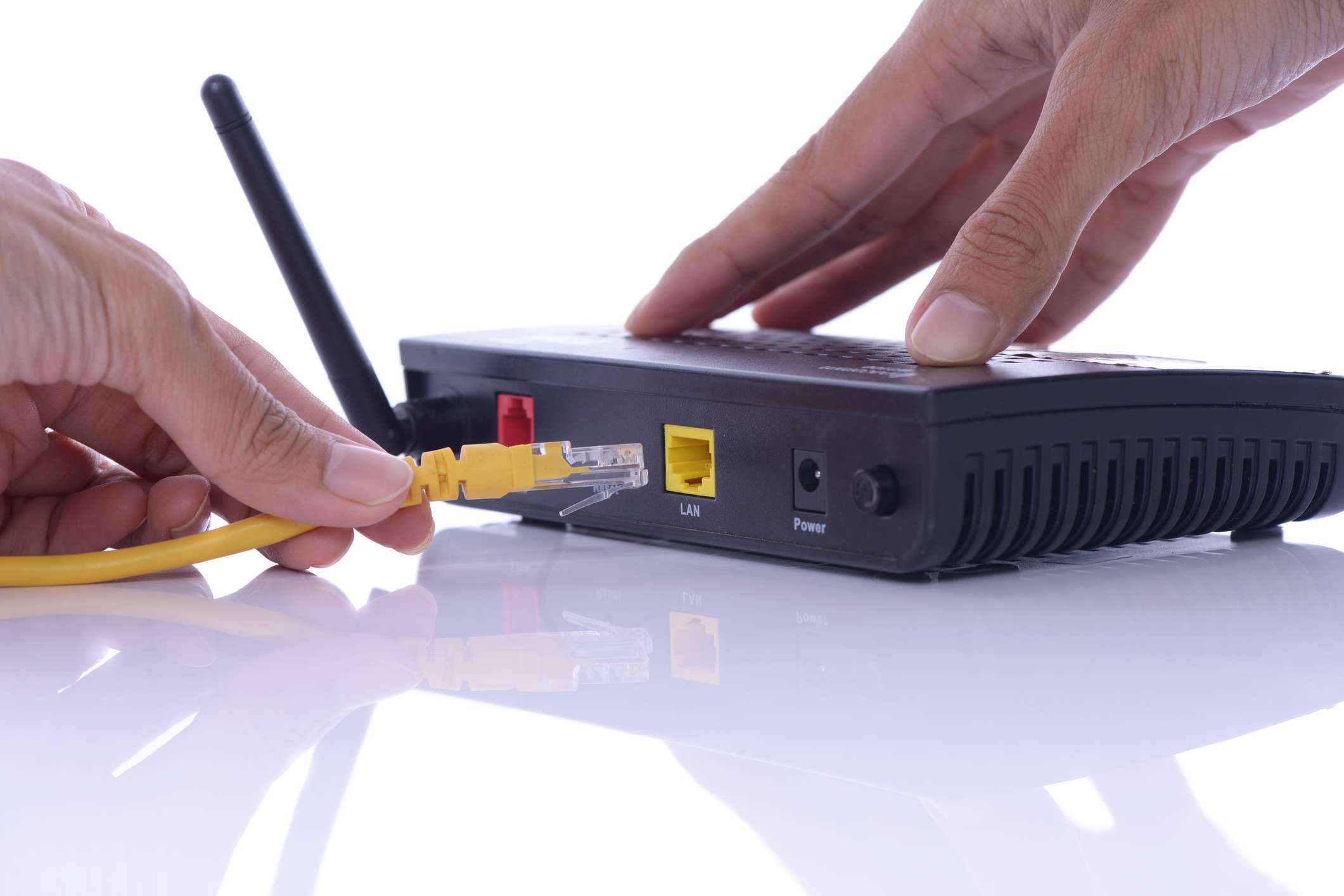 En person som ansluter en Ethernet-kabel till en trådlös router