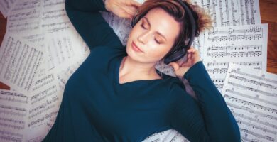 woman listening music while lying on musical notes at home 1132547604 70e701ab02604d37aba477c16a1f7625