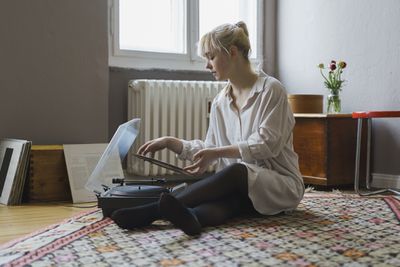 Kvinna som använder skivspelare i vardagsrummet