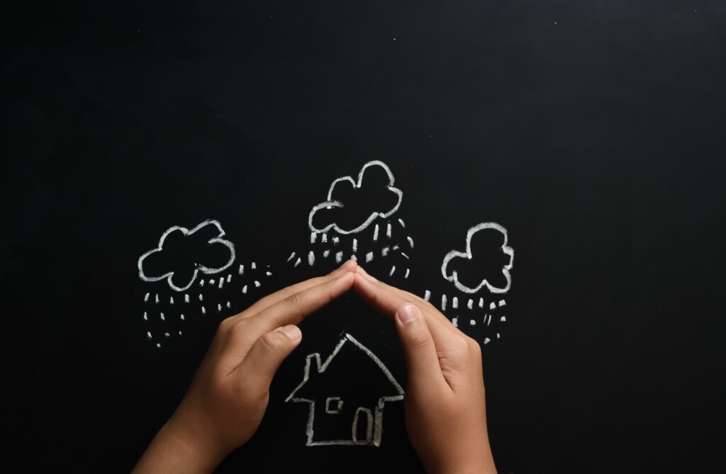 home insurance concept child protecting house by hands with copy space 664923612 5b2ce47704d1cf0036067919