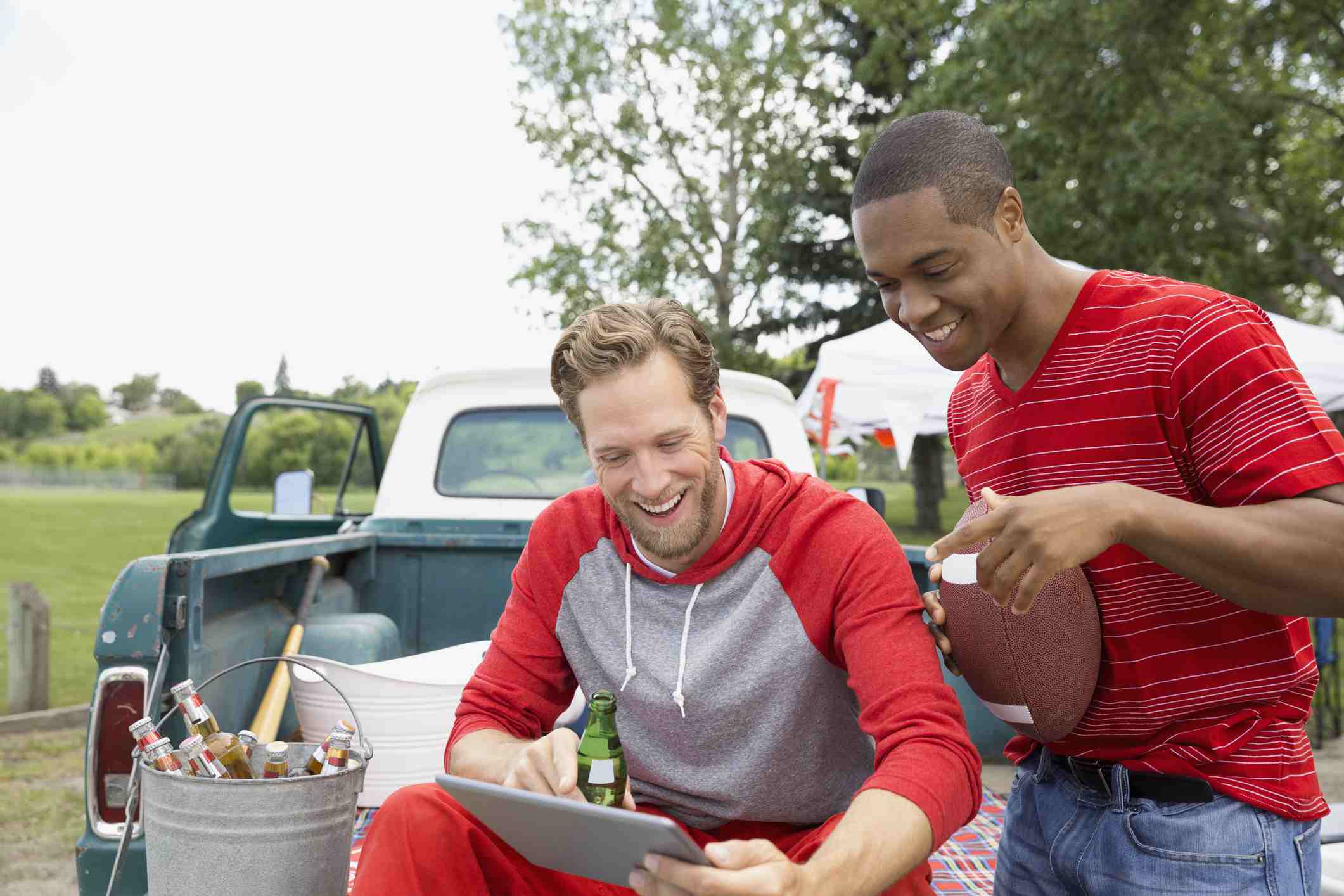 10 Fantastiska Tailgating -tekniker 4 Män tittar på mobilvideo medan de svävar.