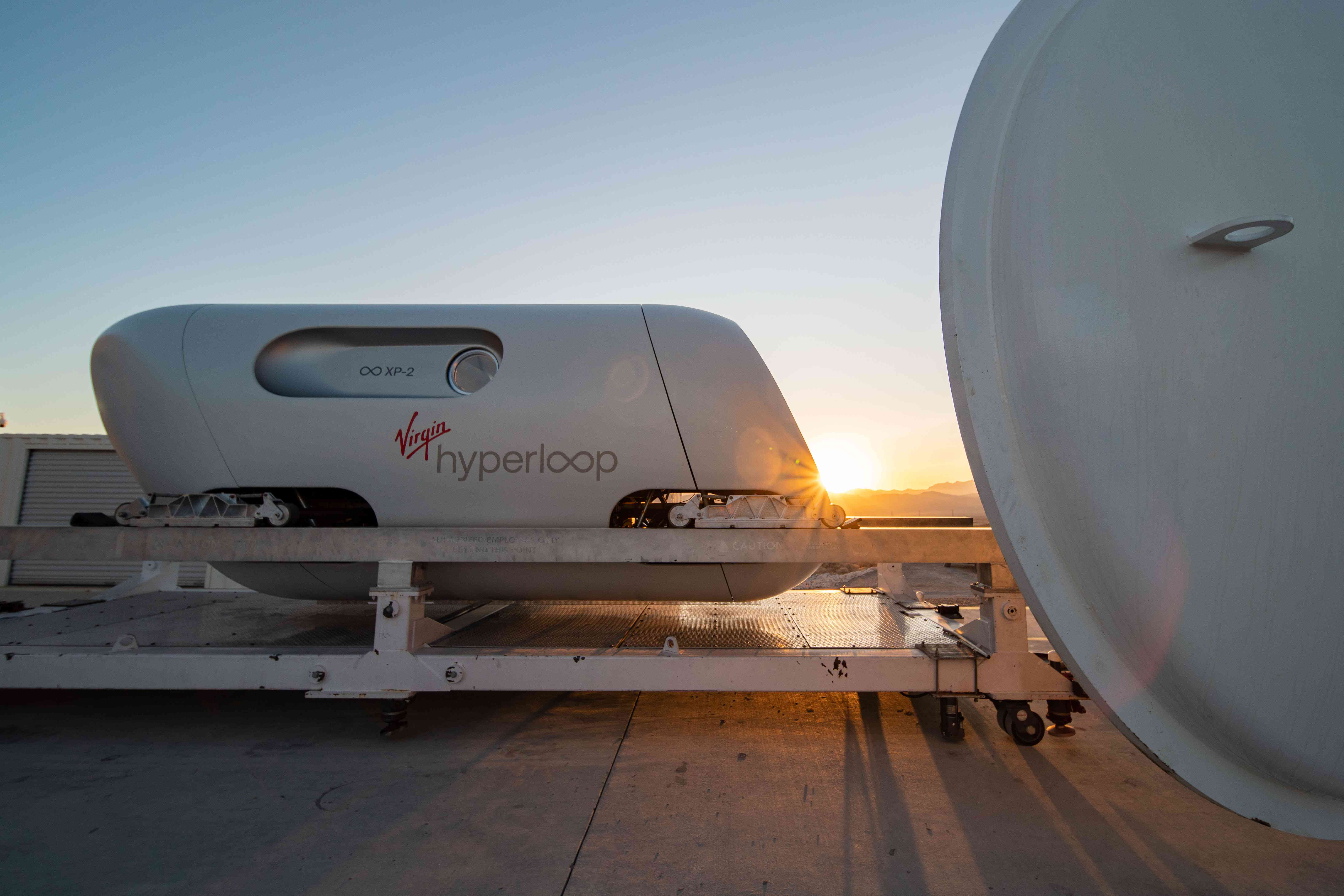 Virgin Hyperloops testpod vilar på plattformen med en solnedgång bakom