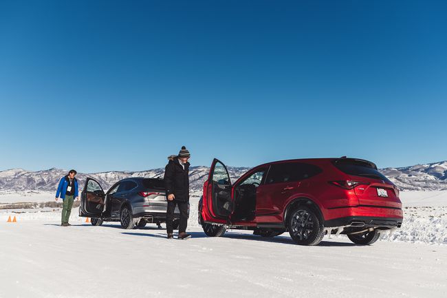 Två förare som testar Bridgestone-däck på stadsjeepar på en snöig väg.